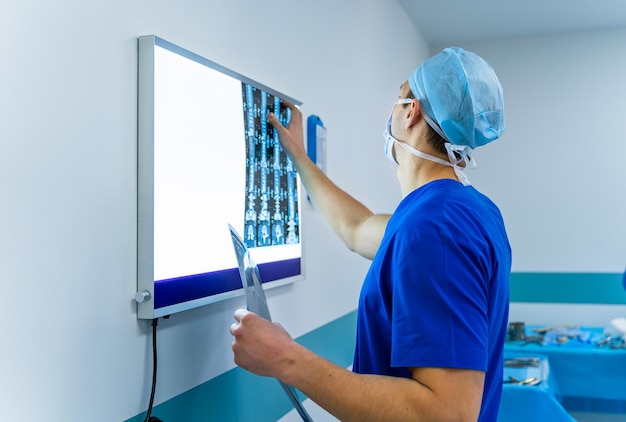 Dokter die een röntgenfoto analyseert Jonge chirurg kijkt naar computertomografie xray-afbeelding