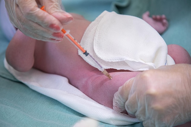 Foto dokter die het eerste vaccin geeft aan de pasgeborene