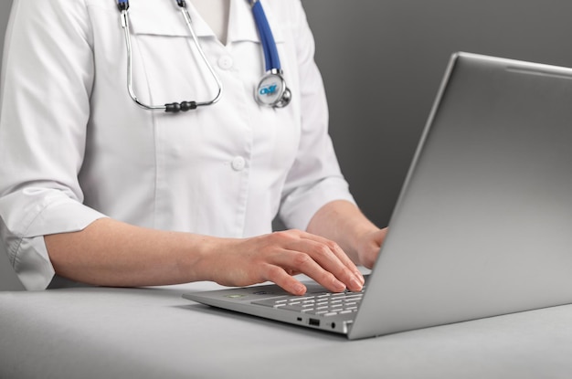 Dokter die op een laptop werkt met behulp van informatietechnologieën en AI