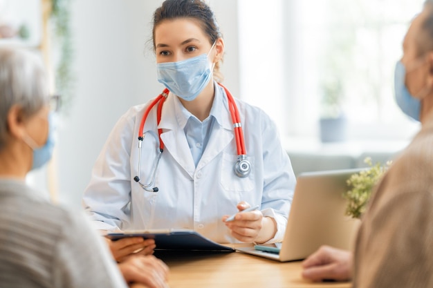 Dokter en oudere echtpaar met gezichtsmaskers