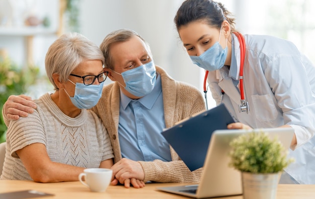 Dokter en oudere echtpaar met gezichtsmaskers