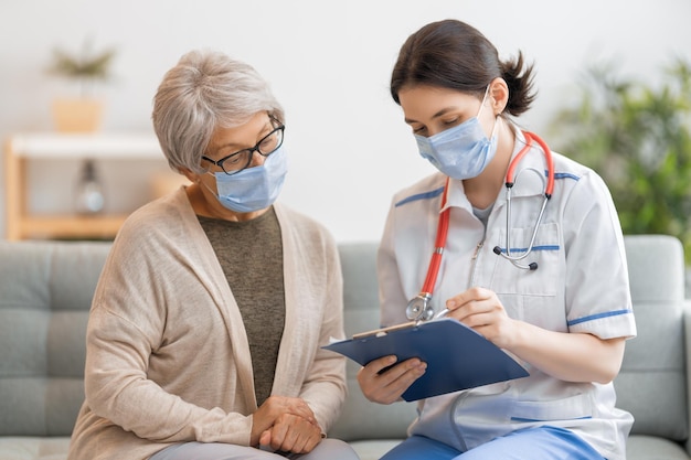 Dokter en oudere vrouw met gezichtsmaskers.