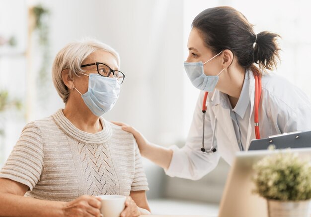 Dokter en oudere vrouw met gezichtsmaskers.