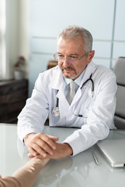 Dokter en patiënt bespreken iets gewoon handen aan tafel