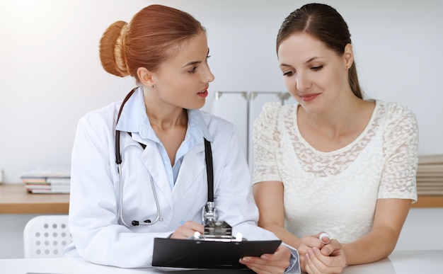 Dokter en patiënt zitten aan het bureau.