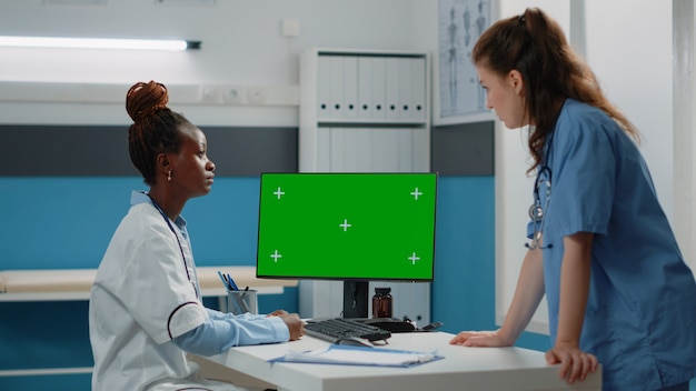 Dokter en verpleegster werken met horizontaal groen scherm