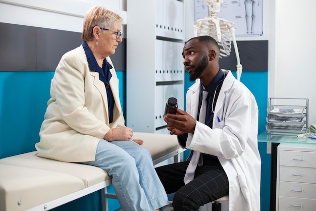 Dokter geeft medicijn aan oudere patiënt