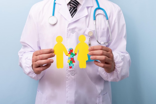 Dokter handen met familie figuur met kind met puzzel vorm Autisme spectrum stoornis concept World Autism Awareness Day