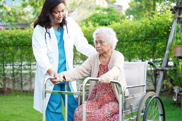 Foto dokter helpt aziatische bejaarde vrouw met een handicap patiënt lopen met rollator in verpleegkundig ziekenhuis medisch concept