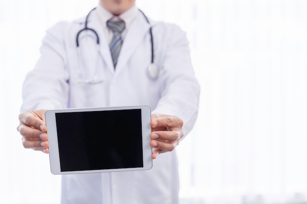 Dokter houdt digitale tablet met leeg scherm in het ziekenhuis