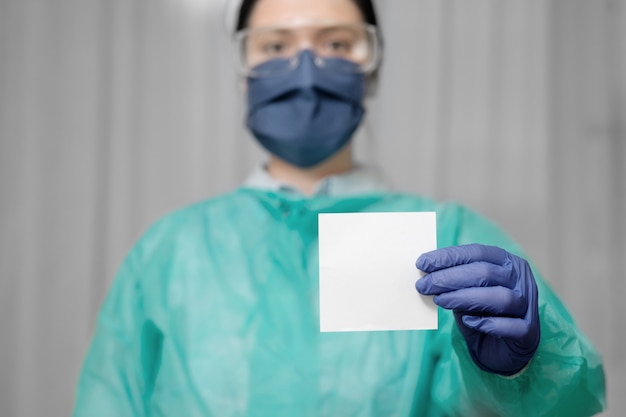 Dokter houdt een stuk papier voor tekst, blijf thuis, beroep van dokter in coronavirusepidemie