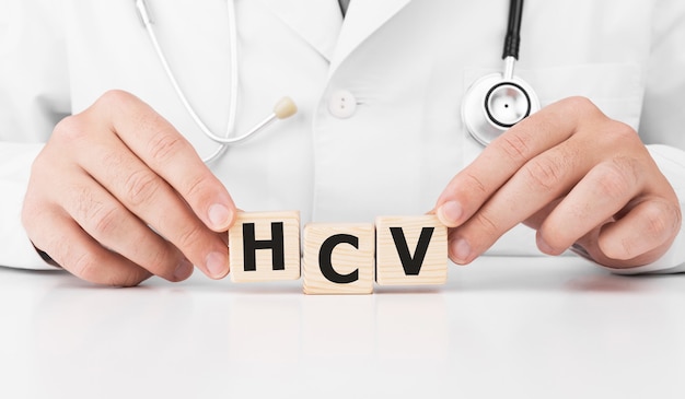 Dokter houdt houten blokjes in zijn handen met de tekst hcv