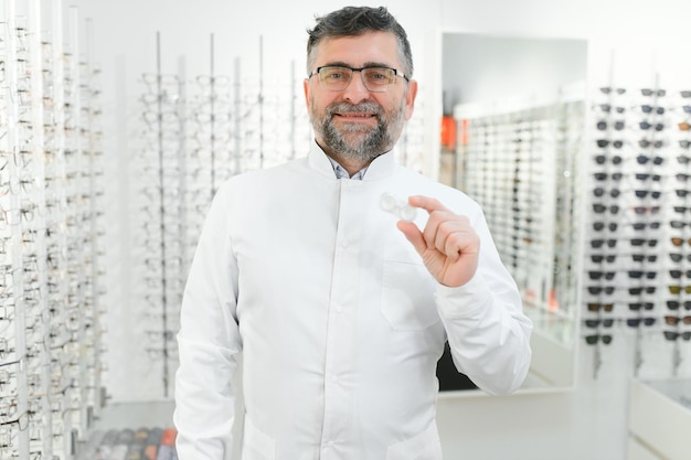 Dokter houdt in zijn handcontainer met zachte contactlenzen voor eenmalig gebruik Oogarts schrijft gebruik van daglenzen voor zichtcorrectie voor Bijziendheid en gezichtsvermogen probleemconcept