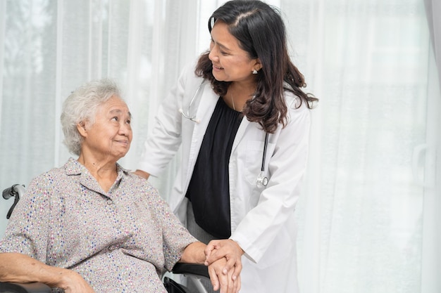 Dokter hulp en zorg Aziatische senior of oudere oude dame vrouw patiënt zittend op rolstoel op verpleegafdeling gezond sterk medisch concept