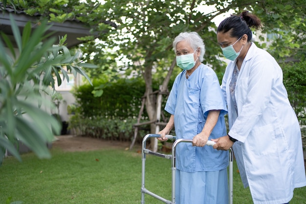 dokter hulp en zorg Aziatische senioren of ouderen gebruiken rollator in park