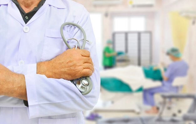 Dokter in een witte jurk houdt de stethoscoop vast in de operatiekamer met wazige beelden
