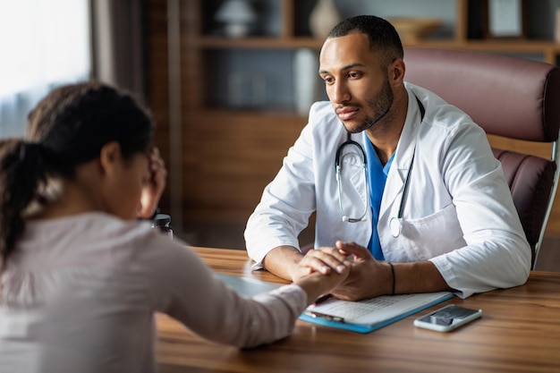 Dokter in gesprek met boos zwarte vrouw patiënt hand in hand?