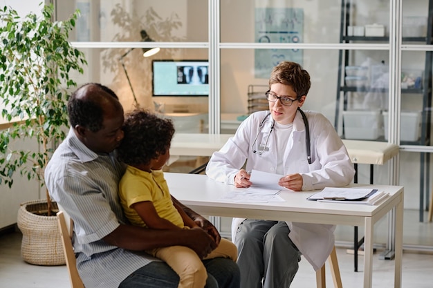 Dokter in gesprek met kind op kantoor