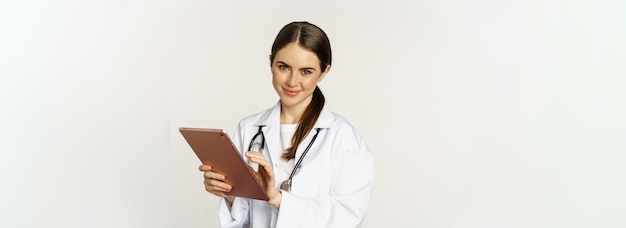 Dokter in witte jas met behulp van digitale tablet die medische gegevens leest over gadget die in het ziekenhuis werkt
