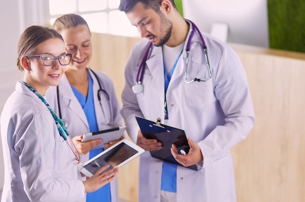 Dokter laat iets in zijn tablet zien aan zijn medisch team