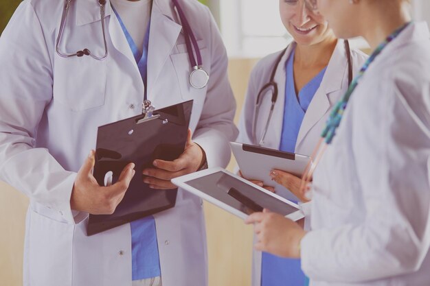 Dokter laat iets in zijn tablet zien aan zijn medisch team