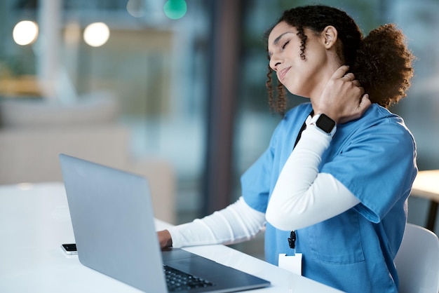 Dokter laptop en nekpijn 's nachts in doodsangst gestrest of burn-out door bureau in het ziekenhuis Vrouw medische professional die lijdt aan pijnlijke verwonding, pijn of ontsteking die laat op de computer werkt