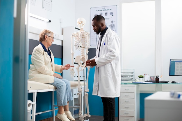 Dokter legt de anatomie uit aan een oude patiënt.