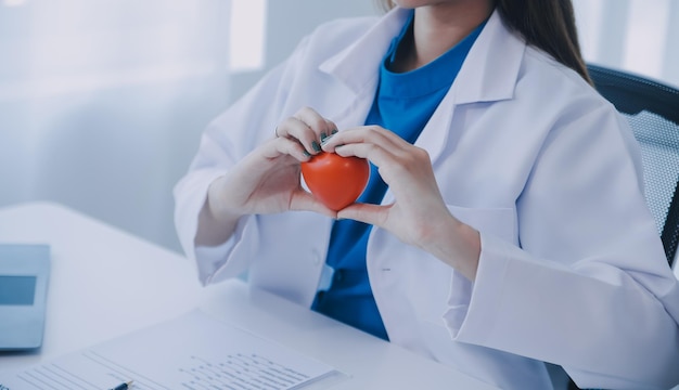 Dokter legt hart uit aan een oudere patiënt Dokter legt het hartmodel uit Dokters wijzen met een pen op een model van het hart