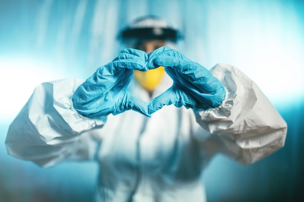 Foto dokter maakt een hart met zijn handen in de covid-afdeling van het coronavirus ziekenhuis.