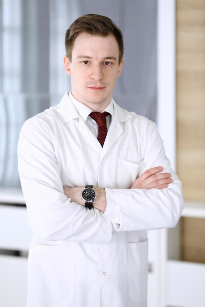 Dokter man headshot terwijl hij in het ziekenhuis kantoor staat Arts op de werkplek portretfoto Geneeskunde en gezondheidszorg concept