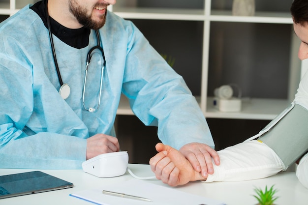 Dokter meet de druk van de patiënt in de kliniek