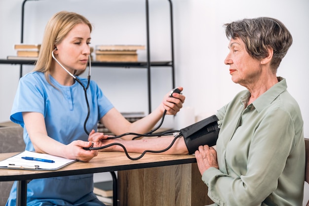 Dokter meet hoge bloeddruk bij een oudere patiënt in de kliniek