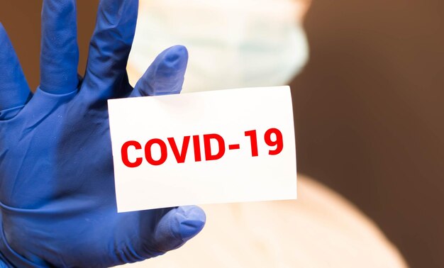 Dokter met een kaart met de tekst COVID19 medische gezondheidszorg concept