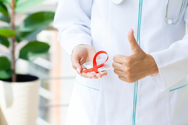 Dokter met een rood lint als symbool van aids