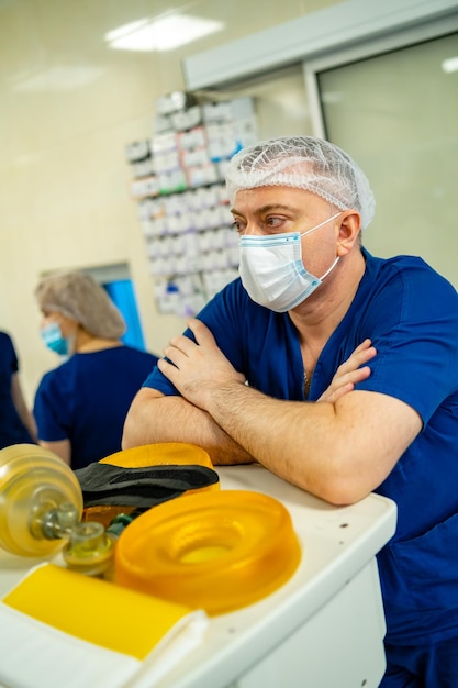 Dokter met masker en scrubs Medician in de buurt van professionele apparatuur voor longventilatie