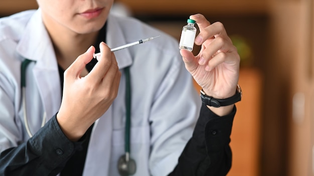 Dokter met vaccinfles en spuit. Geneeskunde en gezondheidszorg concept.