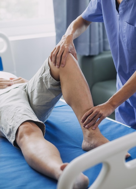 Dokter of fysiotherapeut bezig met het onderzoeken van de behandeling van de gewonde arm van de mannelijke patiënt van de atleet die zich uitstrekt en oefent De pijn van de revalidatietherapie in de kliniek