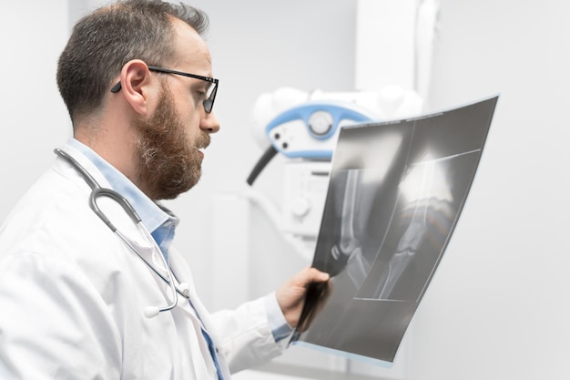Dokter onderzoekt een filmröntgenfoto van een patiënt in de radiologiekamer