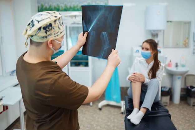 Dokter onderzoekt röntgenfoto's van het been van de patiënt Voet en verstuikingsconcept Sporttrauma's