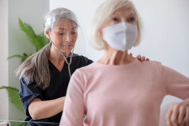 Dokter op bezoek bij senior patiënt thuis afspraak