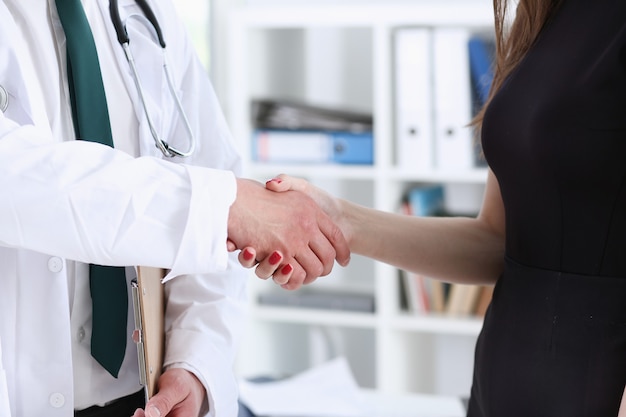 Dokter schudt de hand als hallo met patiënt in kantoorclose-up
