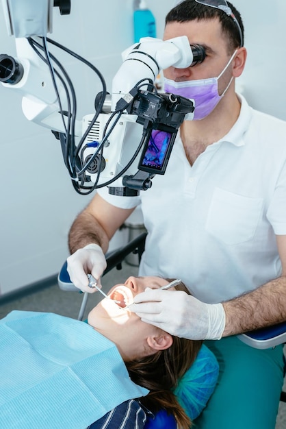 Dokter tandarts gebruikt een microscoop
