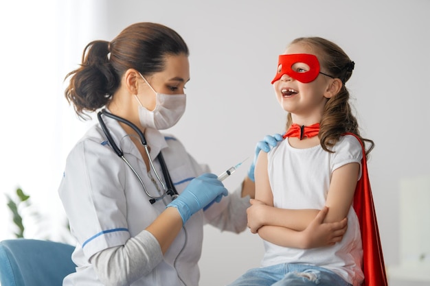 Dokter vaccineert kind in ziekenhuis kind in superheldenkostuum