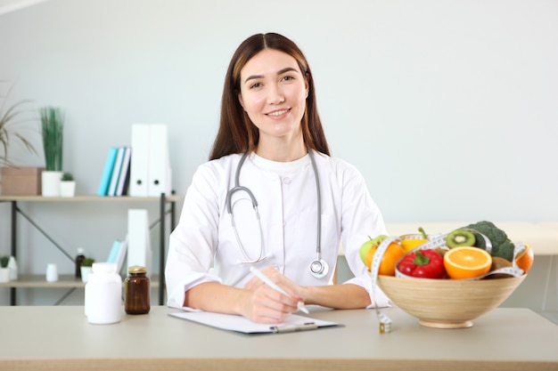 Dokter voedingsdeskundige in haar kantoor demonstreert het concept van gezond eten