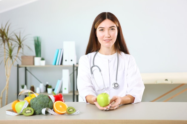 Dokter voedingsdeskundige in haar kantoor demonstreert het concept van gezond eten