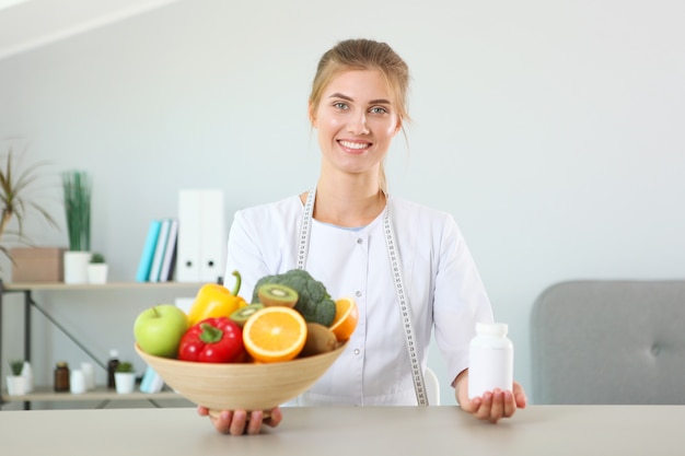 Dokter voedingsdeskundige in haar kantoor demonstreert het concept van gezond eten