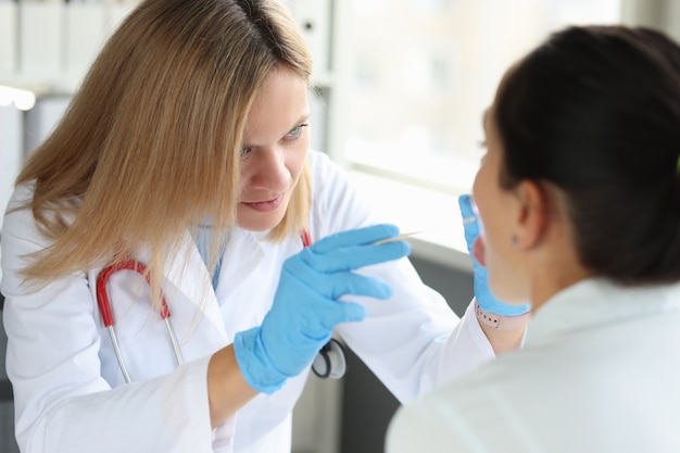 Dokter voert lichamelijk onderzoek uit van het concept van de keel, keel en strottenhoofd van de patiënt