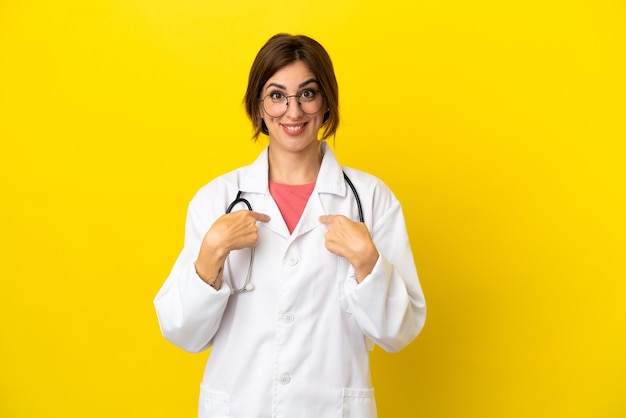 Dokter vrouw geïsoleerd op gele achtergrond met verrassing gezichtsuitdrukking