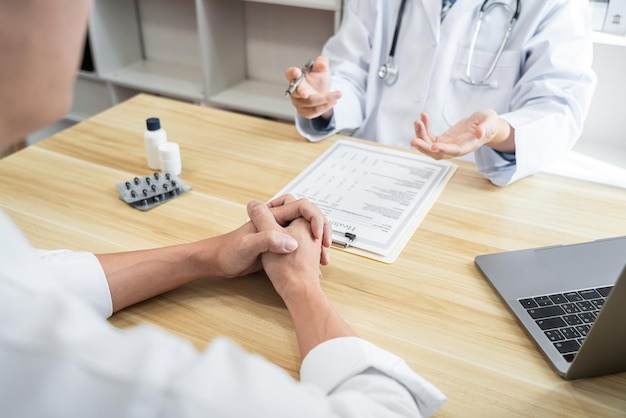 Foto dokter werkt aan de diagnose en adviseert iets over een methode met patiëntenbehandeling na resultaten over het probleem van de ziekte van de patiënt