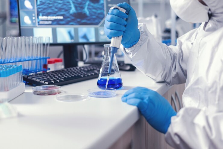 Foto dokter werkt aan het vinden van een remedie voor coronavirus met behulp van micropipet en petrischaal met beschermend pak en gezichtsmasker. chemicus in modern laboratorium die onderzoek doet met dispenser tijdens wereldwijde epidemie